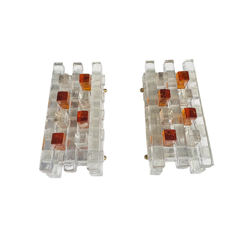 Two matching rectangular wall-mounted light fixtures made of transparent acrylic or glass with small amber-orange square accents, shown on a plain white background.