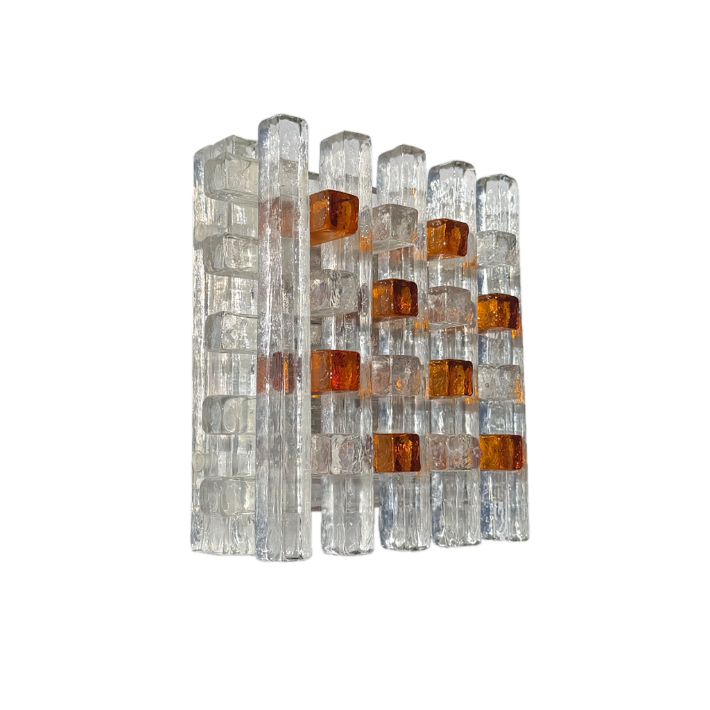 A modern wall-mounted light fixture featuring clear glass rectangular blocks with amber-orange translucent inserts, shown against a plain white background.
