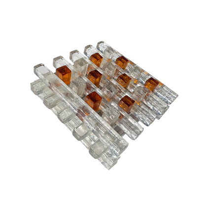 A set of modern mid-century style acrylic and glass block chairs on a solid white background.