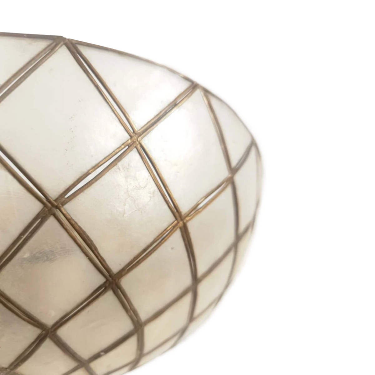 Close-up of a white or off-white egg-shaped decorative object with a metallic gold grid pattern, shown against a plain white background.