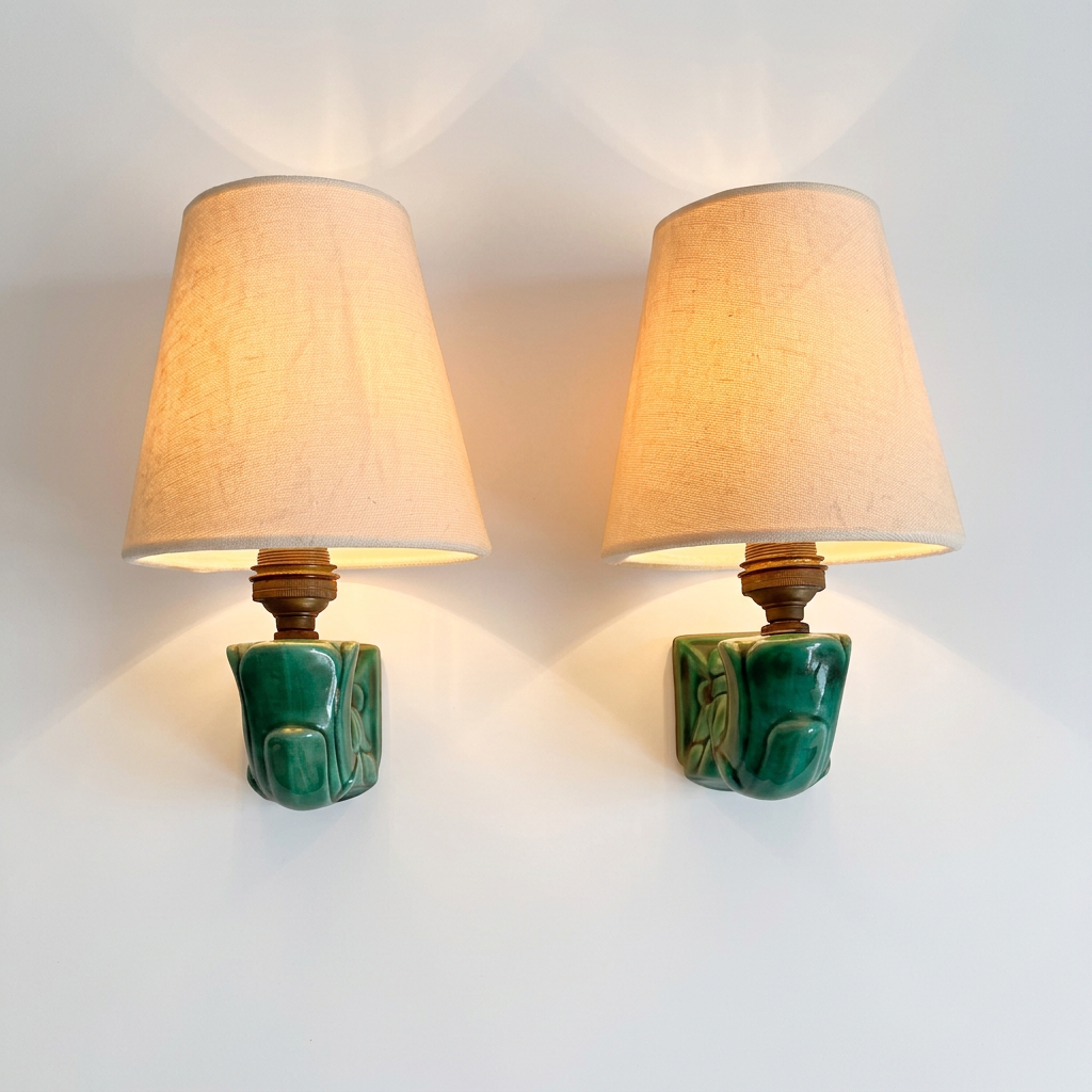 Pair of French emerald green filigree ceramic wall sconces with white linen shades, 1940s. illuminated.