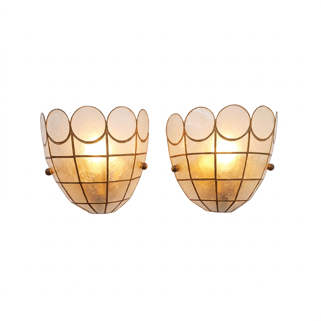 A pair of vintage-style wall sconces with scalloped glass shades and a grid pattern, glowing with warm light against a white background.