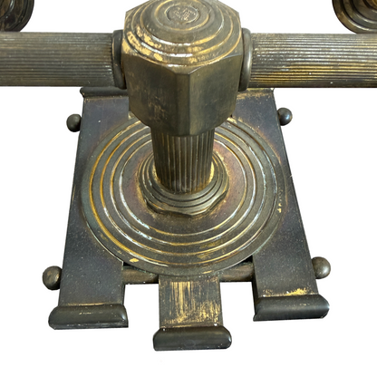 Close-up of concentric bullseye medallion and scored vertical lines on cast brass sconce