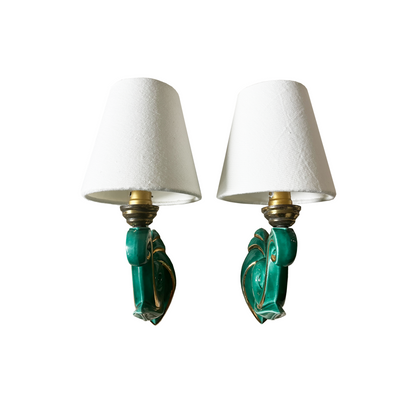 Close-up of green ceramic glaze and gold accent work along the curled arm of the vintage French sconce