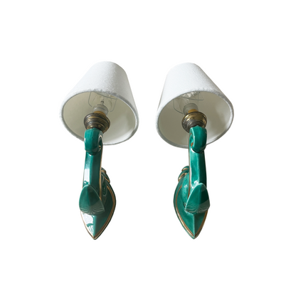 Side profile of mid-century French ceramic wall light showing sculptural curled arm form
