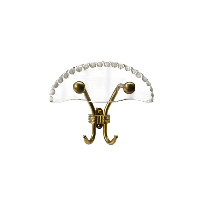 Close-up of hand-chiselled perspex half-moon detail on Italian brass wall hook