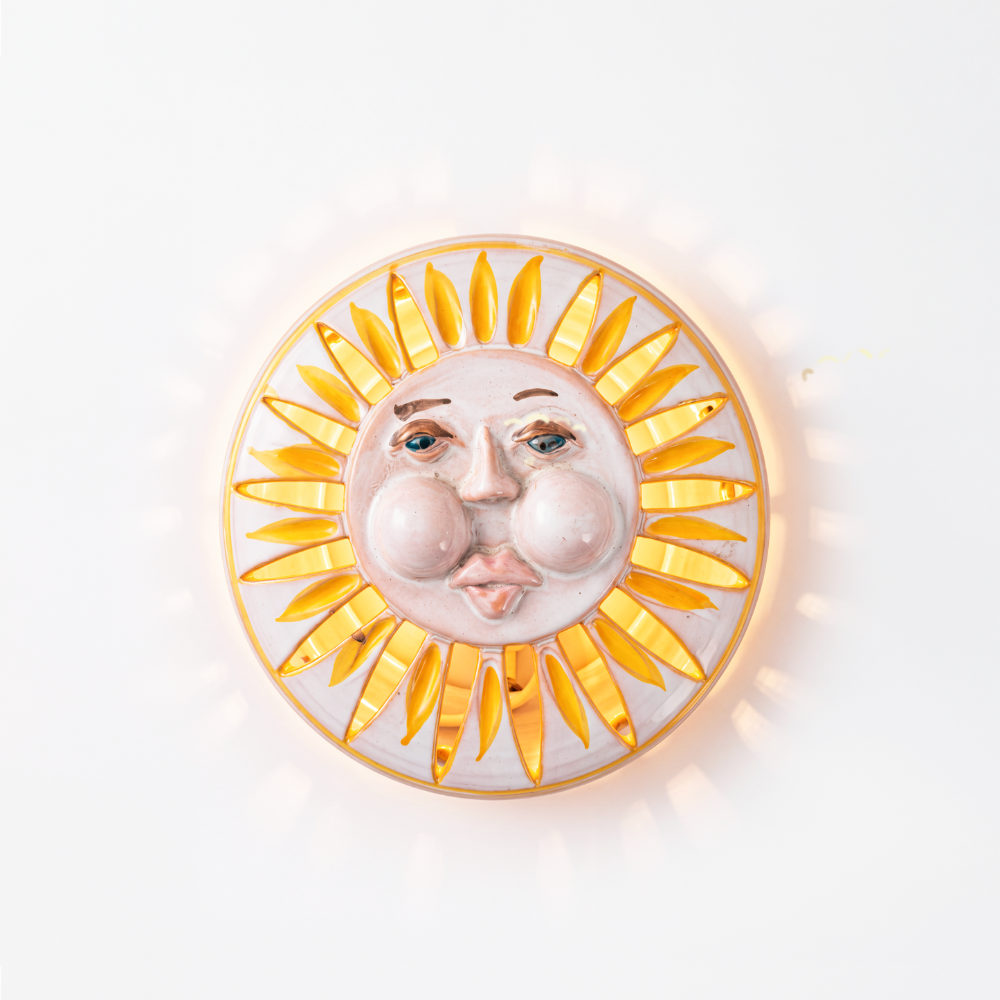 Cutout ray pattern casting light and shadow on vintage Italian ceramic sunburst wall light