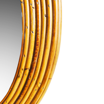 Close-up detail of hand-woven rattan texture and warm honey patina on vintage Italian mirror